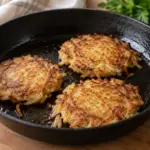 Galettes de pommes de terre rĂąpĂ©es dorĂ©es dans une poĂȘle.